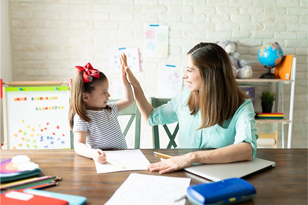 Homeschool parent and student celebrating completed copywork practice